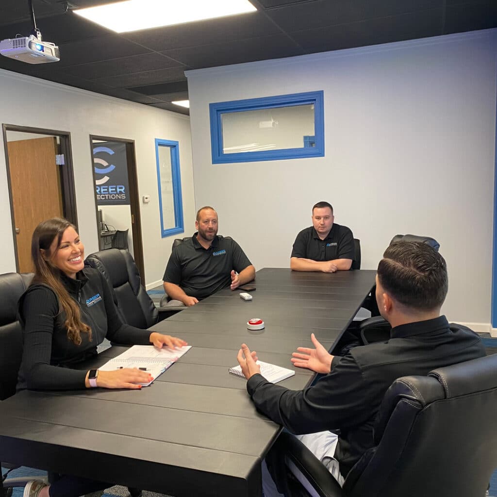 Several professionals from the Career Connections team discussing staffing needs in a conference room.